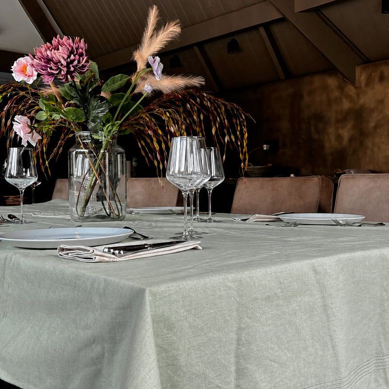 Groen tafellaken op gedekte tafel