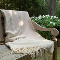 Beige plaid grand foulard op houten bankje buiten | gerecycled katoen