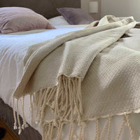 Zand beige sprei met franjes op bed | Lantara