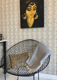 Gevouwen lichtgrijze grand foulard of plaid op stoel